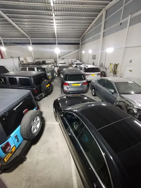 Workshop hall with customer cars including a Jeep Wrangler and a Mercedes-Benz GLE