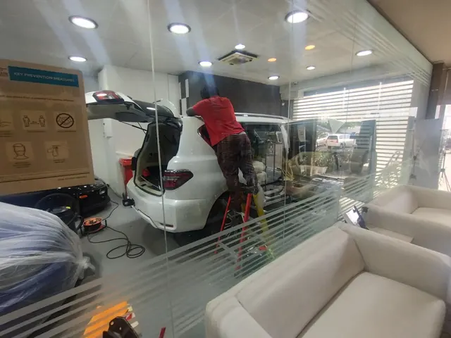 A technician working on a Nissan Patrol, seen from the customer lounge