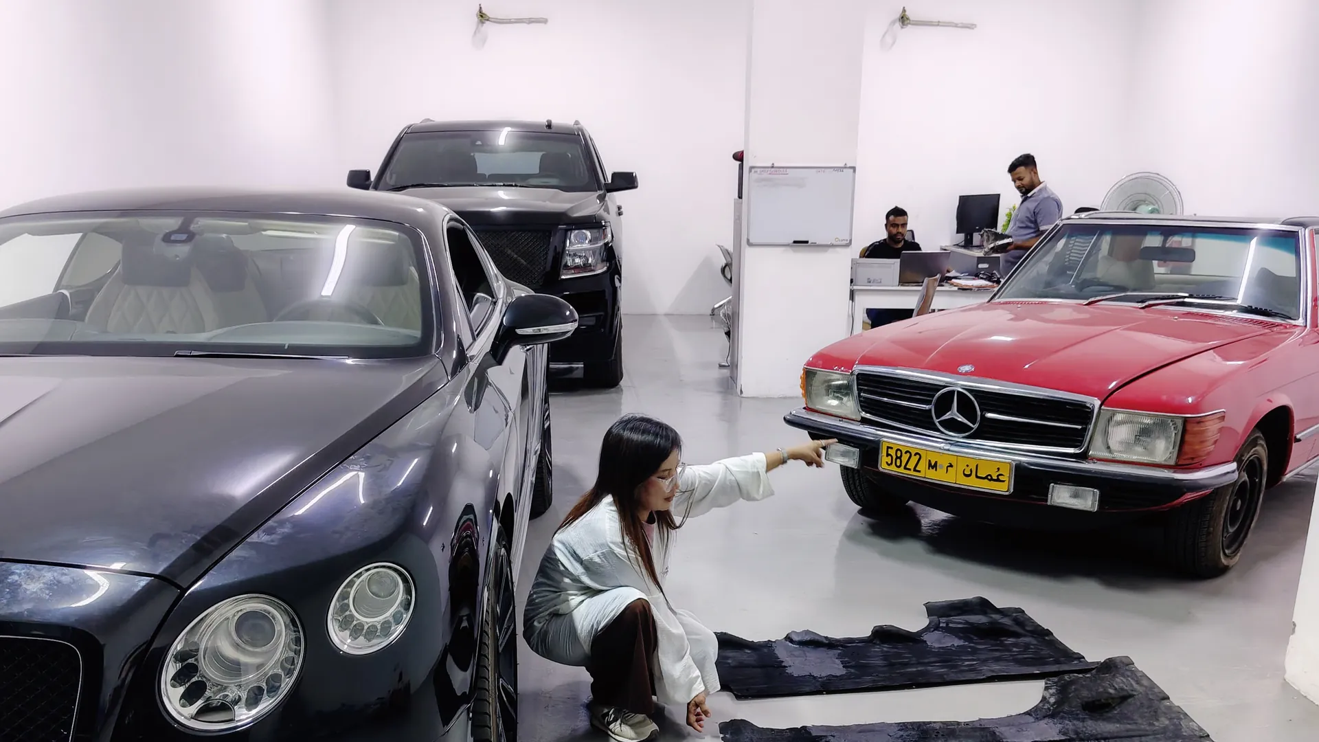 A black Bentley Continental GT, a red Mercedes-Benz SL and a black Cadillac Escalade inside the Garage Lutis workshop
